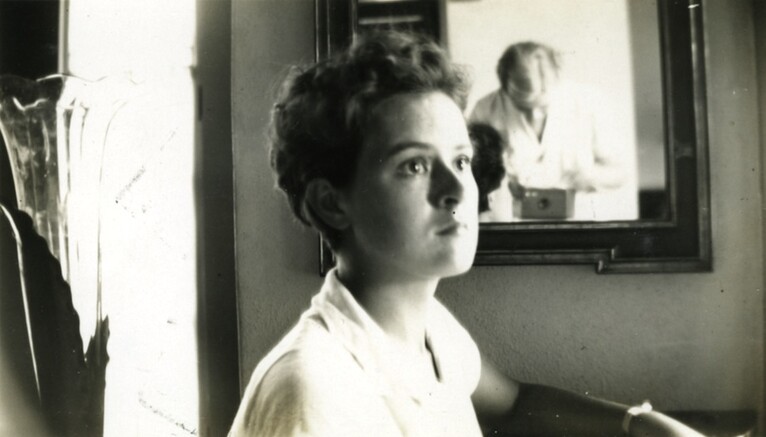 <em>Ruth Reed, reflected in mirror, takes a photograph of a friend. Courtesy of the Reed family.</em>